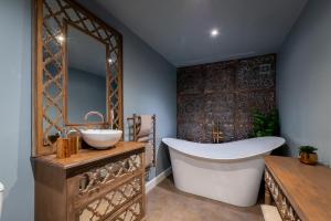 a bathroom with a tub and a sink and a mirror at Lincoln Yurts in Lincoln