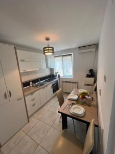 a kitchen with a wooden table and a table and chairs at Concept home Valcea in Râmnicu Vâlcea