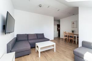 ein Wohnzimmer mit einem Sofa und einem Tisch in der Unterkunft Apartament Mierzeja Wiślana in Sztutowo