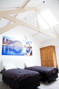 2 camas en una habitación con paredes y techos blancos en La Casita bed and breakfast, en Voorschoten