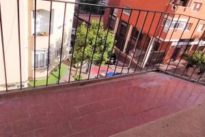 una valla frente a un edificio con árboles en Beautiful private and exterior double room. en Esplugues de Llobregat