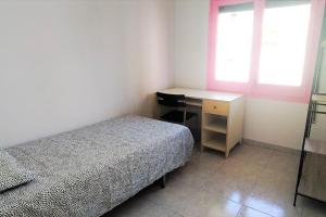 1 dormitorio con cama, escritorio y ventana en Beautiful private and exterior double room., en Esplugues de Llobregat