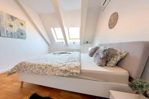 Dormitorio blanco con cama con almohadas en Old Town Beautiful Mansard, en Bucarest