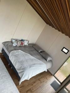 een groot bed in een kamer met een muur bij Looduskeskne Olivia moodulmaja Põltsamaal 