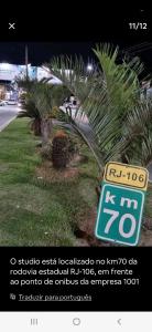 a sign that is next to a palm tree at Estúdio em Bacaxa in Saquarema