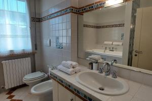 W łazience znajduje się umywalka, toaleta i lustro. w obiekcie A Casa DaNoi w mieście San Clemente