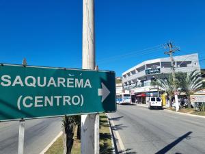 a green street sign on the side of a road at Estúdio em Bacaxa in Saquarema