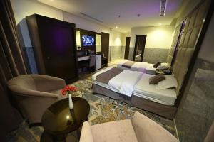 a hotel room with two beds and a television at Aster Hotel in Jeddah