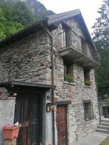 um edifício de pedra com uma varanda e uma porta em Casa Prucci em Battigio