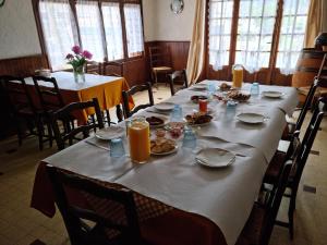 Au Pont de la Ginéze في Barjac: غرفة طعام مع طاولة طويلة مع أطباق من الطعام