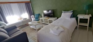 um quarto com uma grande cama branca e um sofá em Kortteer vihreä huone em Rauma