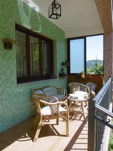 d'un balcon avec des chaises, une table et des fenêtres. dans l'établissement Doniños, maravilla del mundo, te esperamos., à Ferrol