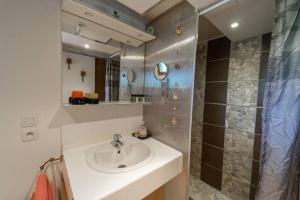 ein Bad mit einem Waschbecken und einer Dusche in der Unterkunft Appartement in Doussard