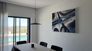 un comedor con una mesa y una pintura en villagoldra rentals - Luxury and Family Villa, en Goldra de Baixo