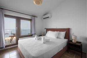 a bedroom with a bed with a view of the ocean at Afytos Wonder View by Luxlikehome in Afitos +36 photos