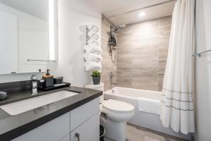 uma casa de banho com um lavatório, um WC e uma banheira em Traveller home in centre Toronto em Toronto