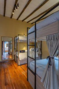 1 dormitorio con 3 literas y espejo en Casa Dreamer Bogotá, en Bogotá
