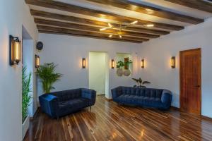 a living room with two blue couches and wooden floors at Casa Dreamer Bogotá in Bogotá