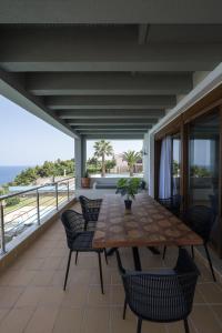 a table and chairs on a balcony with a view of the ocean at Afytos Wonder View by Luxlikehome in Afitos