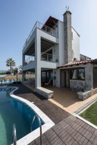 a villa with a swimming pool and a house at Afytos Wonder View by Luxlikehome in Afitos