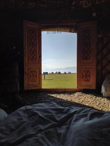 a room with a window with a view of a field at Song Kol lake, Flex Travel yurt camp, horse riding in Song-Kul