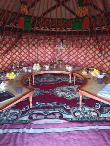a room with two wooden tables in a yurt at Song Kol lake, Flex Travel yurt camp, horse riding in Song-Kul
