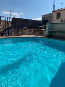 a large pool of blue water in front of a building at La Casita del Patio in Bernardos