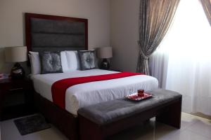 - une chambre avec un grand lit et une table avec un plateau dans l'établissement SteyMorr Guesthouse, à Maun