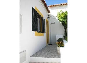 ein weißes Gebäude mit einer Tür und einem Fenster in der Unterkunft Casa Azenhas in Azenhas do Mar