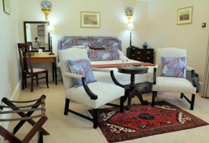 een woonkamer met een tafel en stoelen en een bed bij Hacklewood Hill Country House in Port Elizabeth