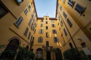 een groot geel gebouw naast twee andere gebouwen bij DUOMO - Prestigious Penthouse with Panoramic View in Milaan