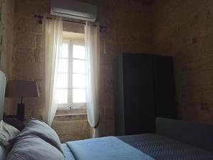 a bedroom with a bed and a window at Beautiful 1-Bed Apartment in Hal Qormi in Qormi +4 photos
