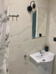 bagno bianco con lavandino e specchio di Modern Penthouse Thessaloniki a Salonicco