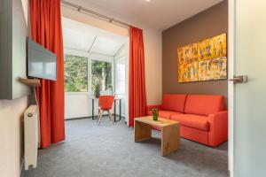 ein Wohnzimmer mit einem roten Sofa und einem Tisch in der Unterkunft Parkhotel Cochem in Cochem