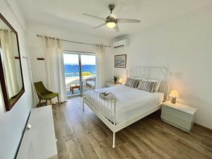 a bedroom with a bed and a balcony with the ocean at Seaview Beach Apartment Dasoudi in Limassol