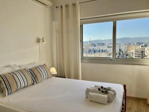 a bedroom with a white bed with a window at Seaview Beach Apartment Dasoudi in Limassol