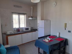 Il comprend une cuisine équipée d'une table et d'un réfrigérateur blanc. dans l'établissement Casa Padrón 2, à El Escobonal