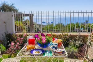 uma mesa com comida e vista para o oceano em YourHome - Relais Loggia Li Galli em Massa Lubrense
