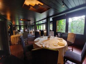 a dining room with tables and chairs and windows at Hotel Etxeberri in Zumárraga