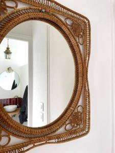 a large mirror with a wooden frame on a wall at T2 chaleureux - wifi - plage et commerces à pieds in Berck-sur-Mer