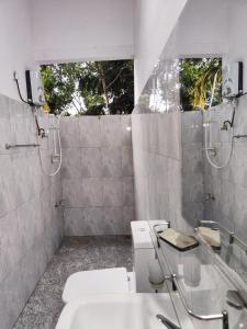 uma casa de banho com um WC, um lavatório e um espelho. em AnandaHomestay em Kandy