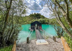 a small shack on a lake with a dock at St Andrews Lakes 