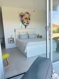 1 dormitorio con 1 cama con una pintura en la pared en CASA LC chambre3 vue mer SPA de NAGE en Ajaccio