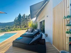 a patio with lounge chairs next to a swimming pool at CASA LC chambre3 vue mer SPA de NAGE in Ajaccio