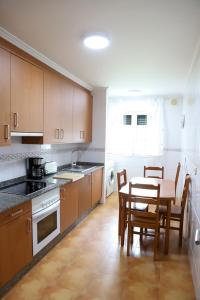 uma cozinha com uma mesa e uma mesa e cadeiras em Apartamento Carrera em Caldas de Reis