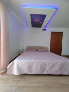 1 dormitorio con 1 cama con una pintura en la pared en Apartments Marjanović, en Zlatibor