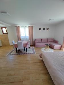 a living room with a pink couch and a table at Apartments Marjanović in Zlatibor
