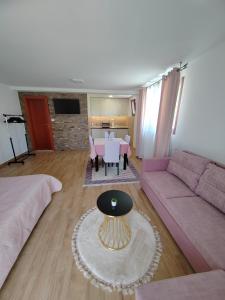 a living room with a pink couch and a table at Apartments Marjanović in Zlatibor
