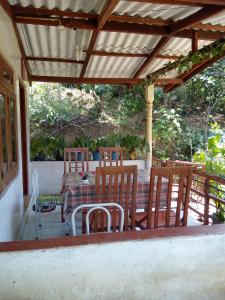 a patio with a table and chairs and a roof at Ella j villa in Ella