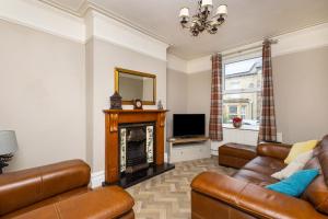 sala de estar con muebles de cuero y chimenea en Horbury High St Wakefield en Horbury